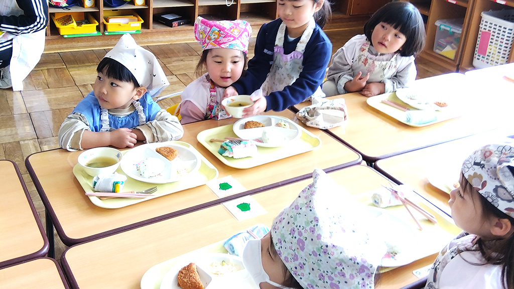 給食　運ぶのが難しい年少組さんを年長組さんがお手伝い。